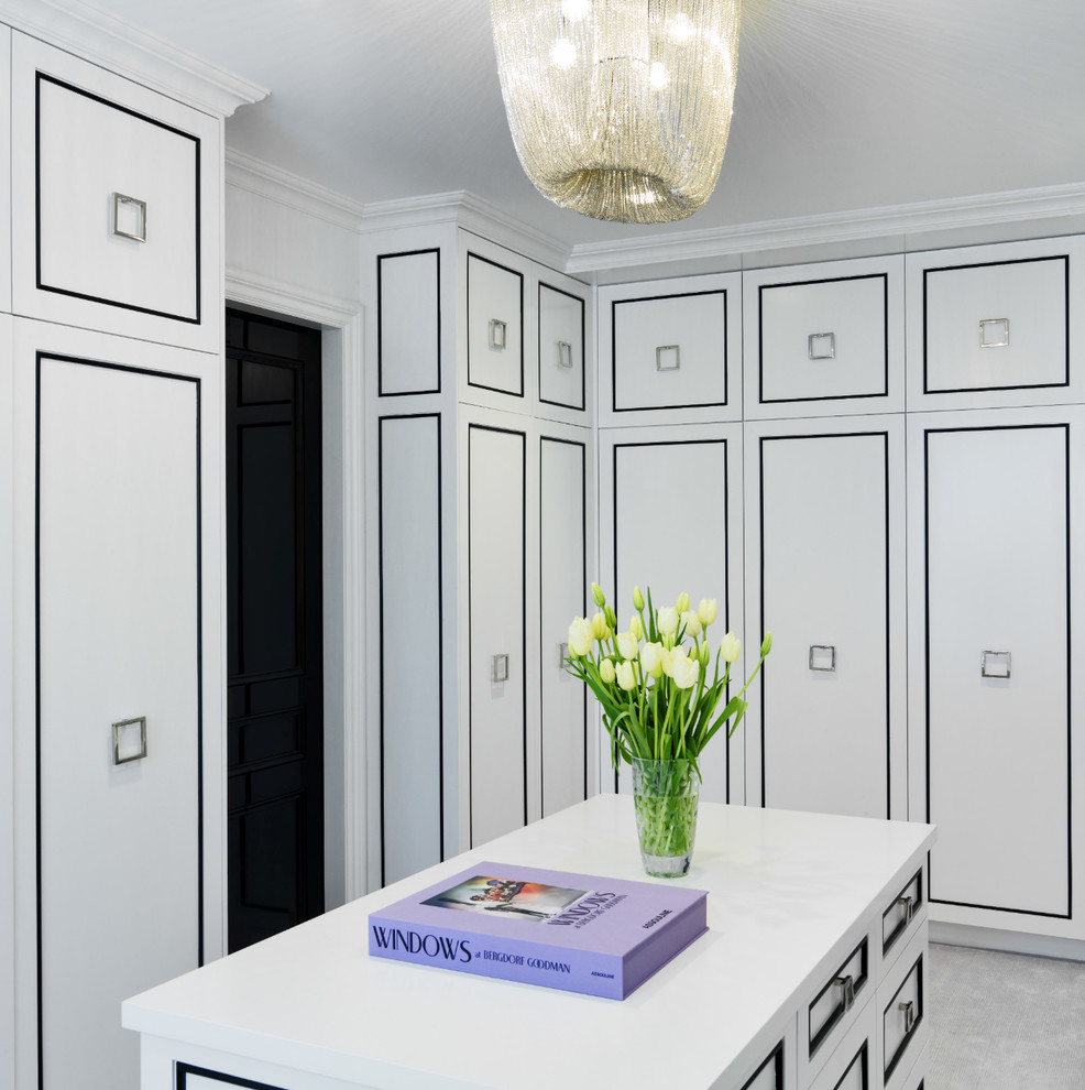 Photo of a transitional women's dressing room in New York with white cabinets and carpet.