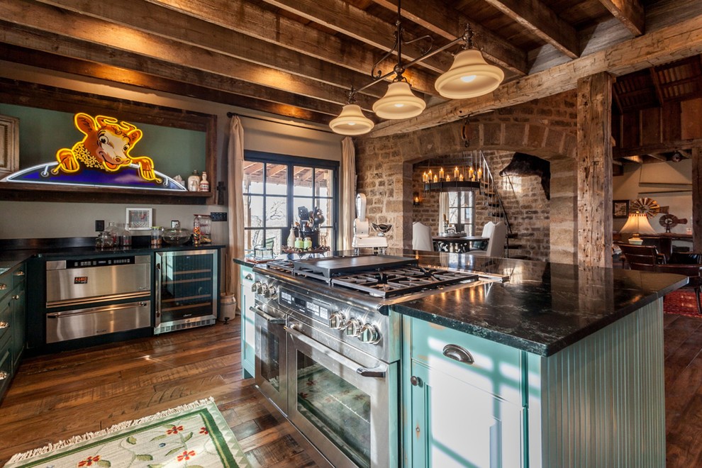 Inspiration for a large rustic u-shaped medium tone wood floor and multicolored floor enclosed kitchen remodel in Austin with beaded inset cabinets, medium tone wood cabinets, soapstone countertops, stainless steel appliances and an island