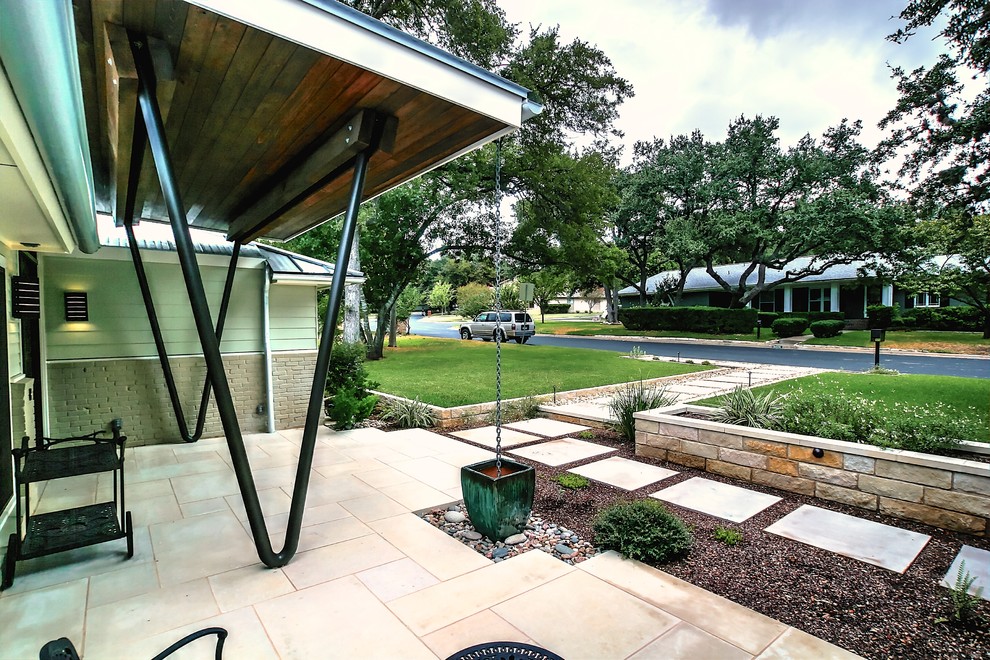 This is an example of a contemporary partial sun garden in Austin with natural stone pavers.