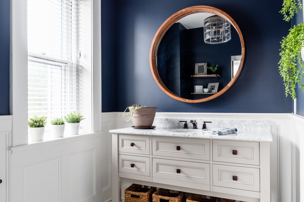 Transitional 3/4 single-sink, wall paneling and wainscoting bathroom photo in Columbus with recessed-panel cabinets, an undermount sink and a built-in vanity