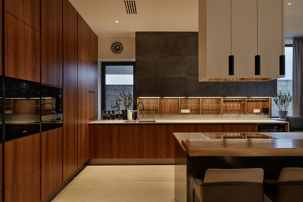 Modelo de cocinas en L contemporánea grande abierta con armarios con paneles lisos, puertas de armario de madera oscura y una isla