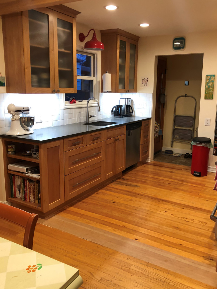 Inspiration for a mid-sized transitional galley medium tone wood floor, brown floor and exposed beam eat-in kitchen remodel in Seattle with an undermount sink, shaker cabinets, medium tone wood cabinets, quartz countertops, white backsplash, subway tile backsplash, stainless steel appliances, a peninsula and gray countertops