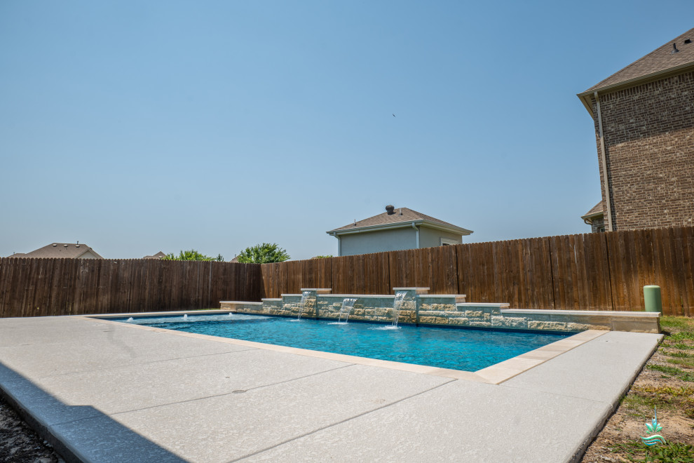 Idee per una piscina monocorsia american style rettangolare di medie dimensioni e dietro casa con paesaggistica bordo piscina e lastre di cemento
