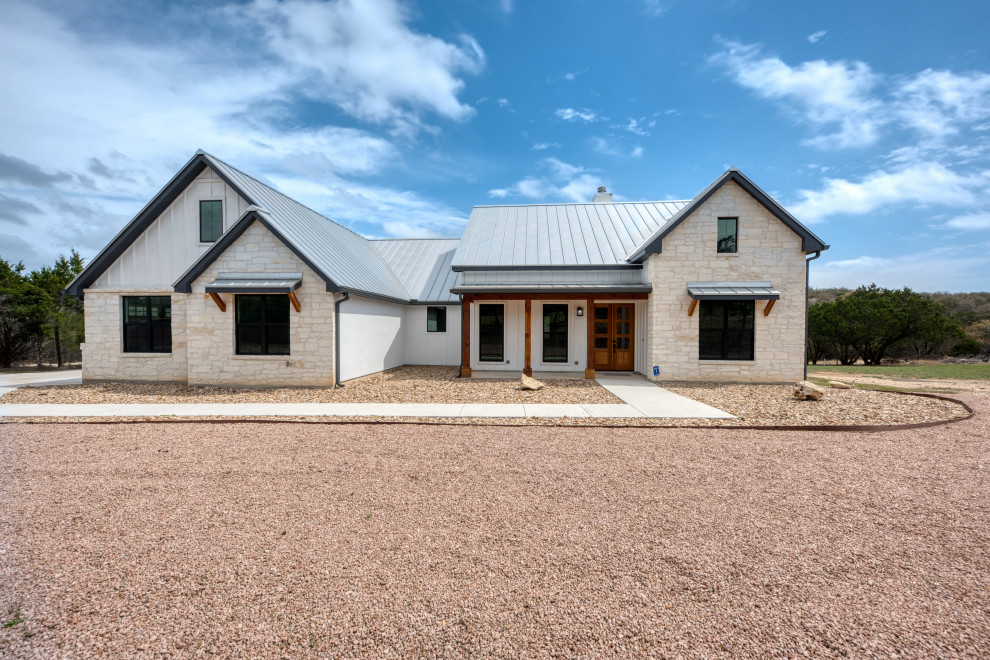 Immagine della villa bianca country a un piano di medie dimensioni in pietra e intonaco con copertura in metallo o lamiera e tetto grigio