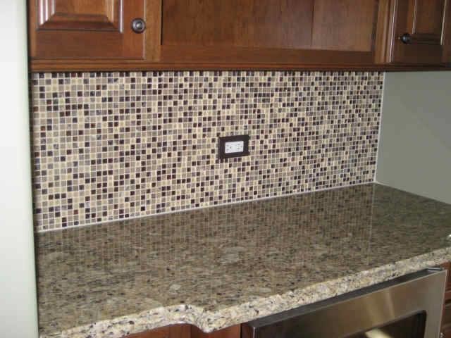 Example of a single-wall open concept kitchen design in Bridgeport with raised-panel cabinets, medium tone wood cabinets, granite countertops, multicolored backsplash and glass sheet backsplash