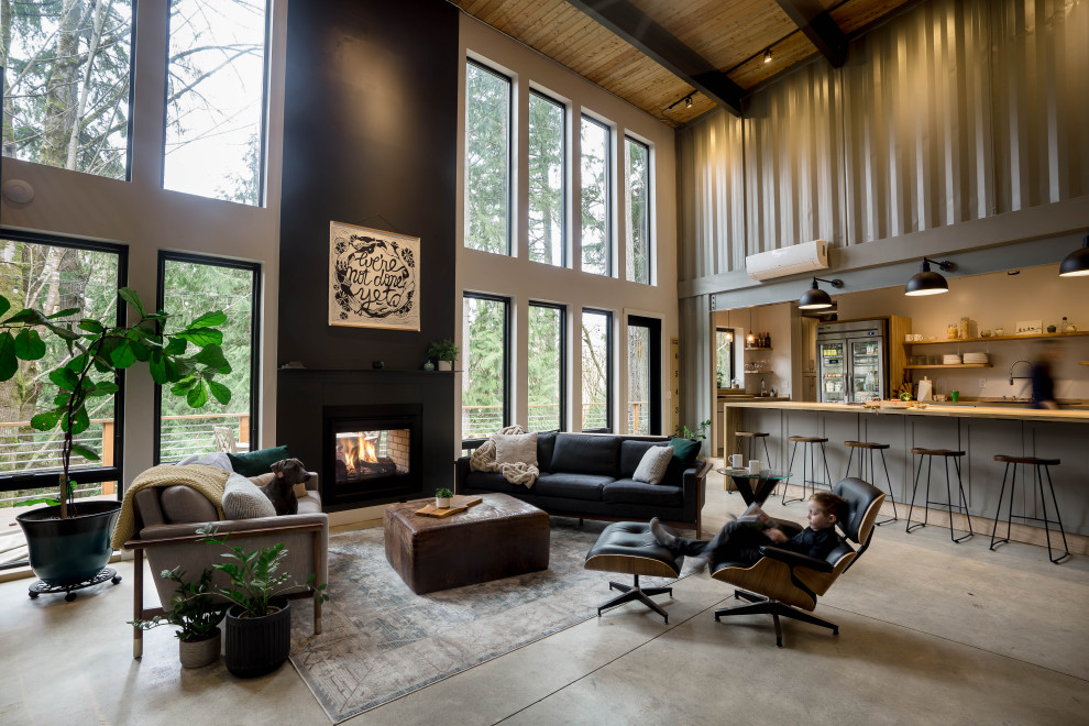 Inspiration for a large industrial open concept family room in Seattle with grey walls, concrete floors, a two-sided fireplace, grey floor and wood.