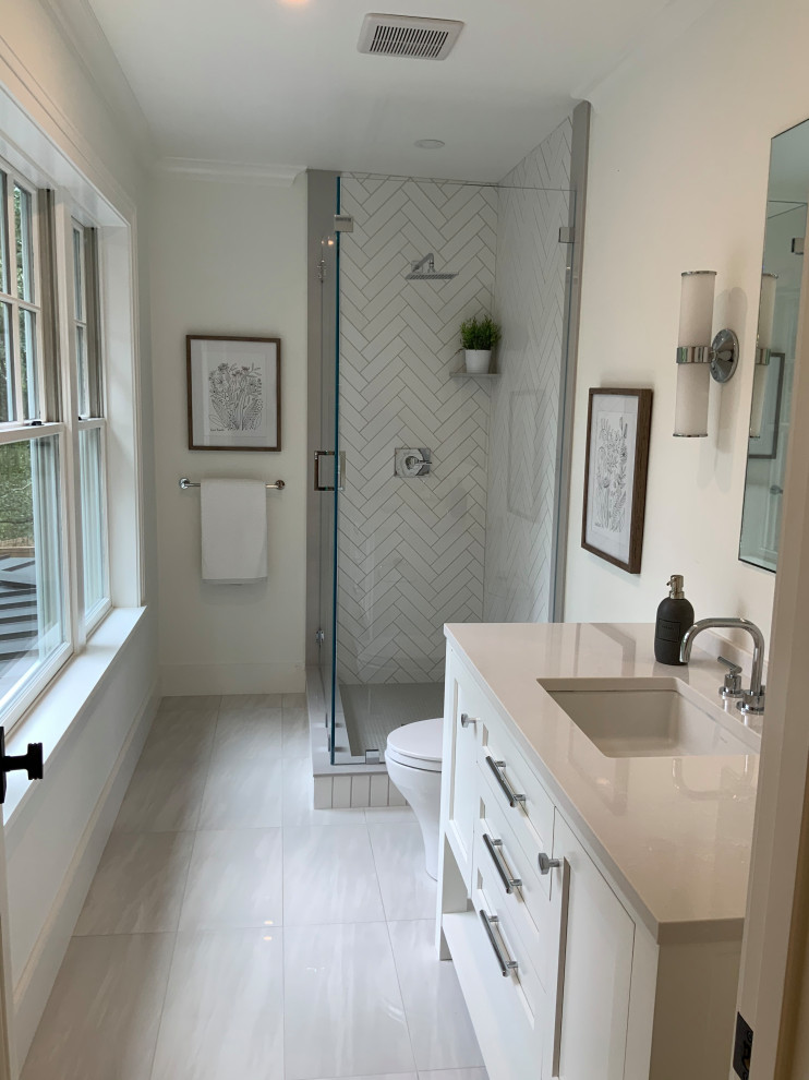 This is an example of a mid-sized transitional kids bathroom in Boston with recessed-panel cabinets, white cabinets, a corner shower, a two-piece toilet, white tile, ceramic tile, white walls, ceramic floors, an undermount sink, engineered quartz benchtops, white floor, a hinged shower door, white benchtops, a single vanity and a built-in vanity.