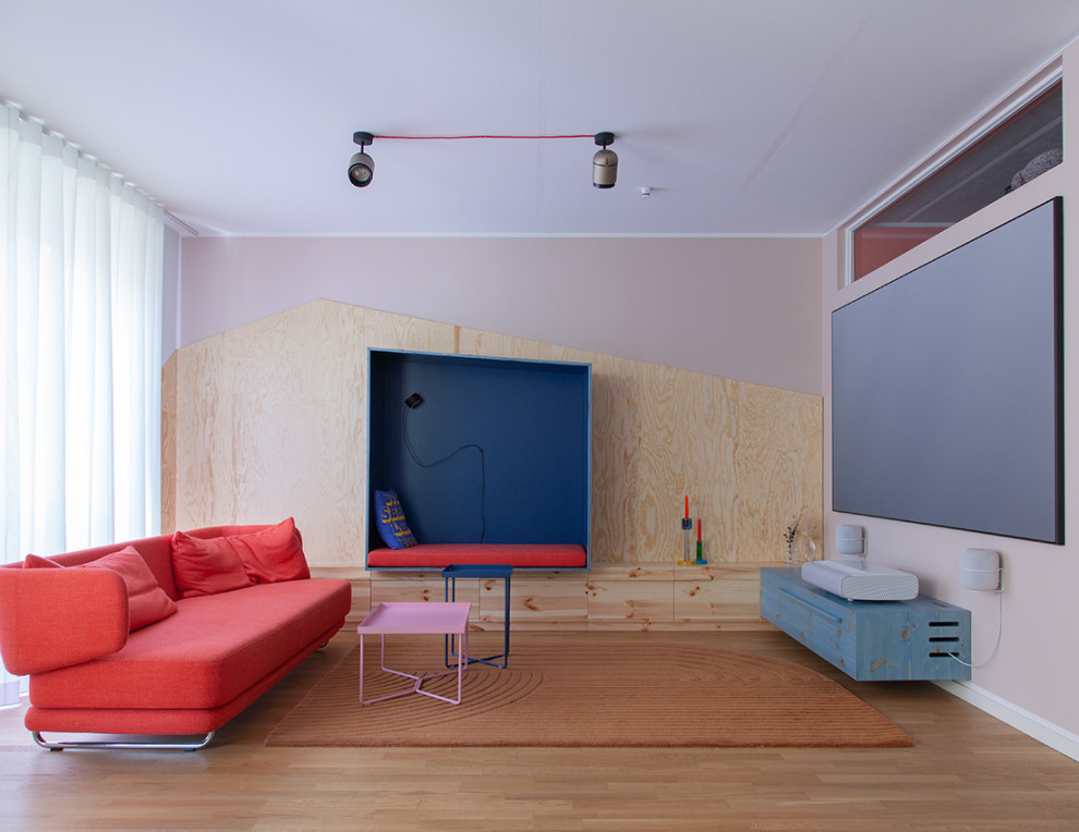 Wohnzimmer With rosa Wandfarbe, braunem Holzboden and braunem Boden in Berlin