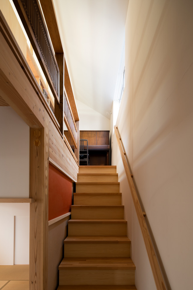 На фото: маленькая угловая деревянная лестница в восточном стиле с деревянными ступенями, деревянными перилами и стенами из вагонки для на участке и в саду с