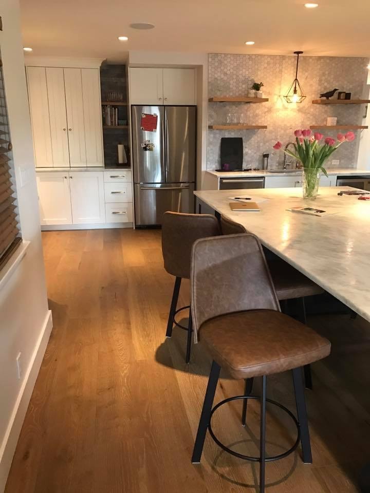 Inspiration for a mid-sized transitional u-shaped eat-in kitchen in Vancouver with an undermount sink, shaker cabinets, white cabinets, marble benchtops, grey splashback, stainless steel appliances, medium hardwood floors, with island, glass sheet splashback and brown floor.