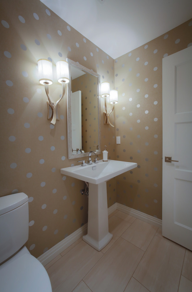 This is an example of a mid-sized transitional powder room in Portland with a two-piece toilet, beige walls, porcelain floors and a pedestal sink.