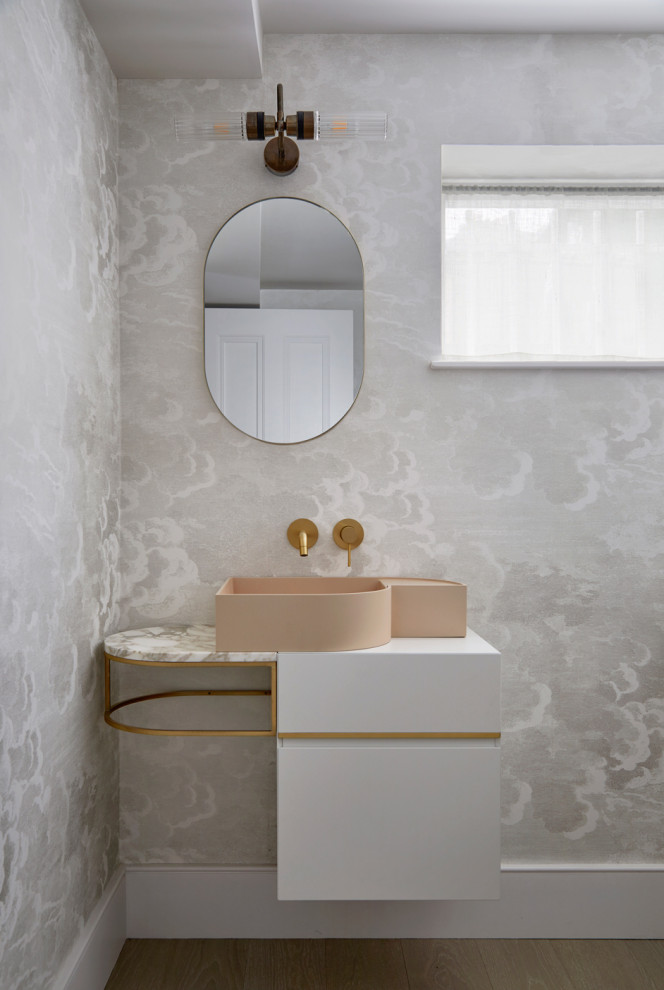 Inspiration for a medium sized contemporary cloakroom in London with flat-panel cabinets, a wall mounted toilet, multi-coloured walls, a wall-mounted sink, granite worktops, beige floors, multi-coloured worktops, feature lighting, a floating vanity unit and wallpapered walls.