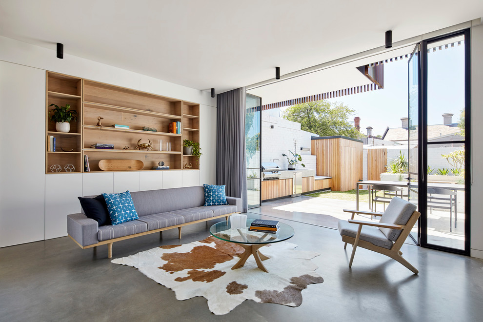 Small contemporary open concept living room in Melbourne with white walls, concrete floors and grey floor.