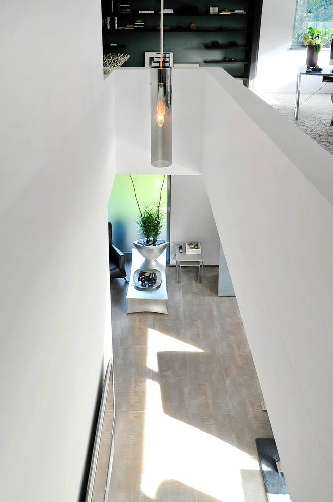 Großer Moderner Flur mit weißer Wandfarbe, Teppichboden und grauem Boden in Berlin