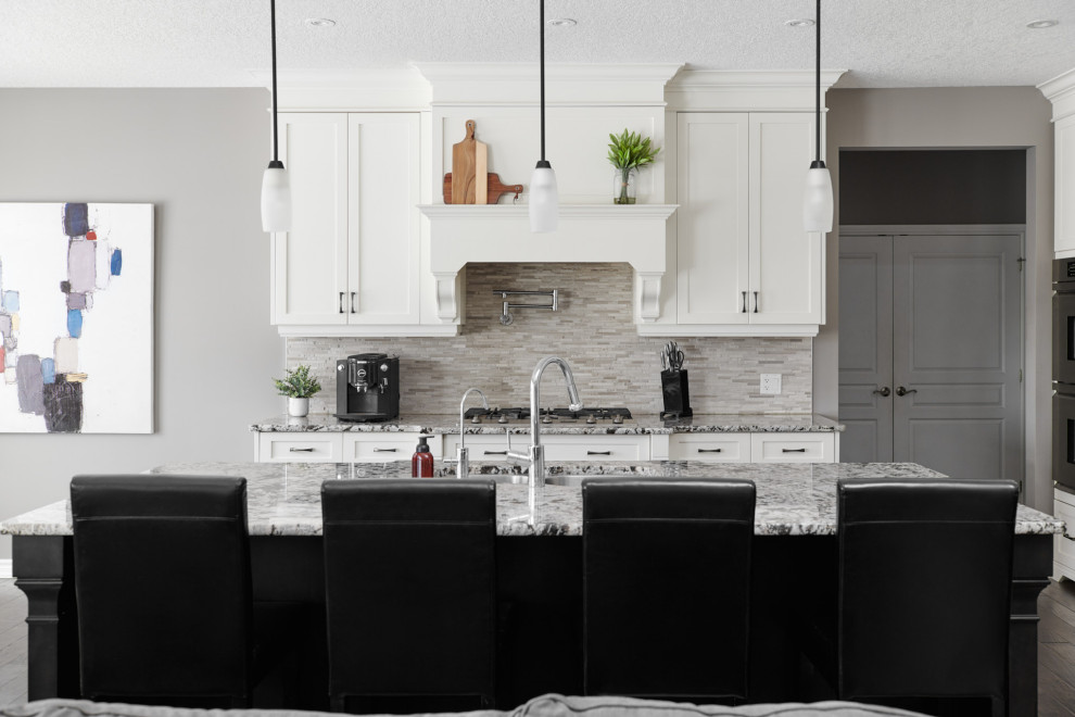Open concept kitchen - transitional dark wood floor and brown floor open concept kitchen idea in Toronto with an undermount sink, shaker cabinets, white cabinets, granite countertops, gray backsplash, stone slab backsplash, stainless steel appliances, an island and gray countertops