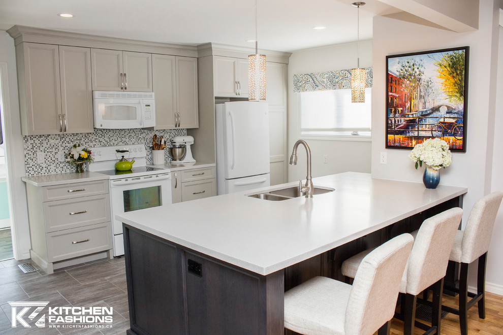 Example of a mid-sized transitional single-wall ceramic tile open concept kitchen design with an undermount sink, shaker cabinets, gray cabinets, solid surface countertops, gray backsplash, mosaic tile backsplash, white appliances and an island