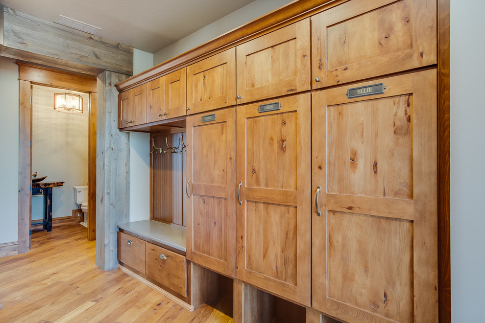 This is an example of a large country mudroom in Other with beige walls and medium hardwood floors.