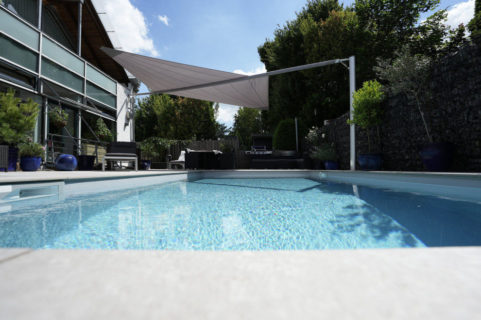Modernes Sportbecken neben dem Haus in rechteckiger Form mit Natursteinplatten in Sonstige