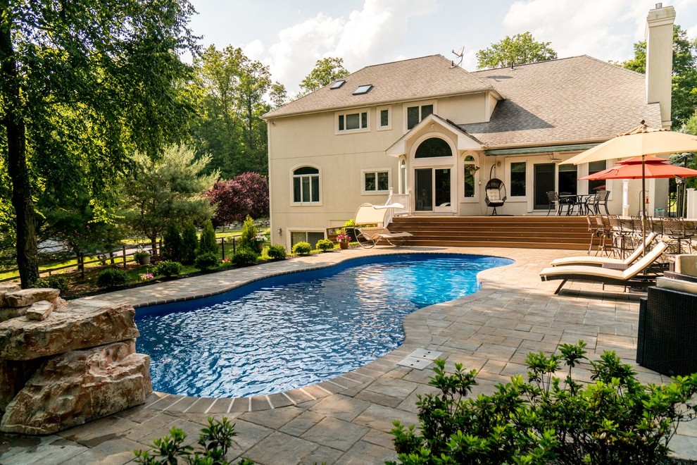 Inspiration for a large mediterranean backyard round pool in New York with natural stone pavers.