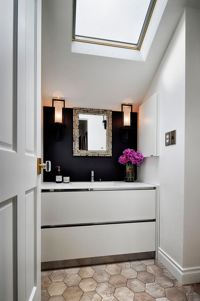 This is an example of a midcentury powder room in Tokyo with flat-panel cabinets, white cabinets, white walls and grey floor.