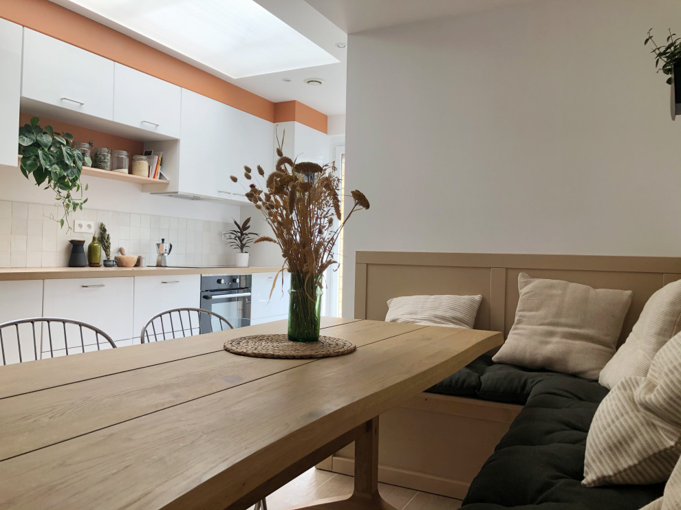 Bild på ett mellanstort funkis beige linjärt beige kök med öppen planlösning, med en undermonterad diskho, luckor med profilerade fronter, vita skåp, laminatbänkskiva, beige stänkskydd, stänkskydd i terrakottakakel, svarta vitvaror och beiget golv