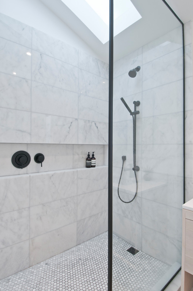 Modern inredning av ett litet vit vitt en-suite badrum, med skåp i ljust trä, en öppen dusch, en toalettstol med hel cisternkåpa, vit kakel, marmorkakel, vita väggar, betonggolv, ett nedsänkt handfat, bänkskiva i kvarts, grått golv och med dusch som är öppen