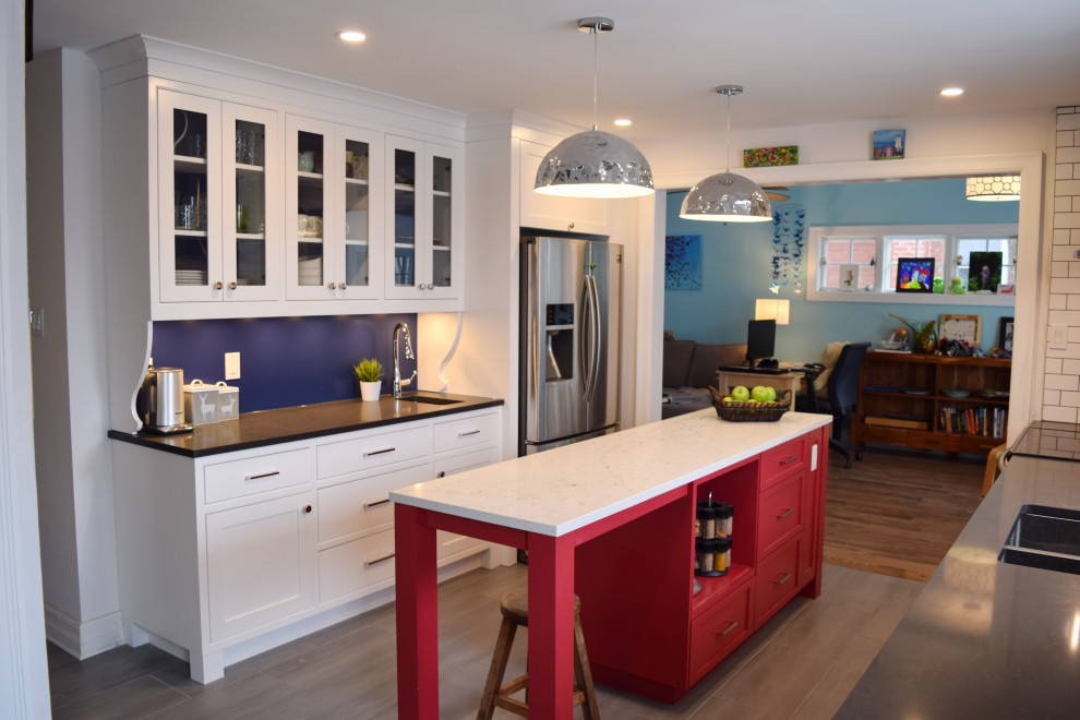 Enclosed kitchen - small eclectic galley light wood floor and beige floor enclosed kitchen idea in Ottawa with an undermount sink, shaker cabinets, white cabinets, quartz countertops, white backsplash, subway tile backsplash, stainless steel appliances, an island and white countertops