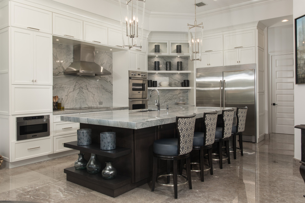 Kitchen - large transitional l-shaped kitchen idea in Miami with an undermount sink, shaker cabinets, white cabinets, quartzite countertops, gray backsplash, stone slab backsplash, stainless steel appliances, an island and gray countertops
