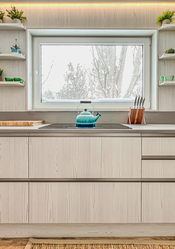 This is an example of a medium sized scandi galley kitchen/diner in Toronto with flat-panel cabinets, light wood cabinets, engineered stone countertops, light hardwood flooring, no island and grey worktops.