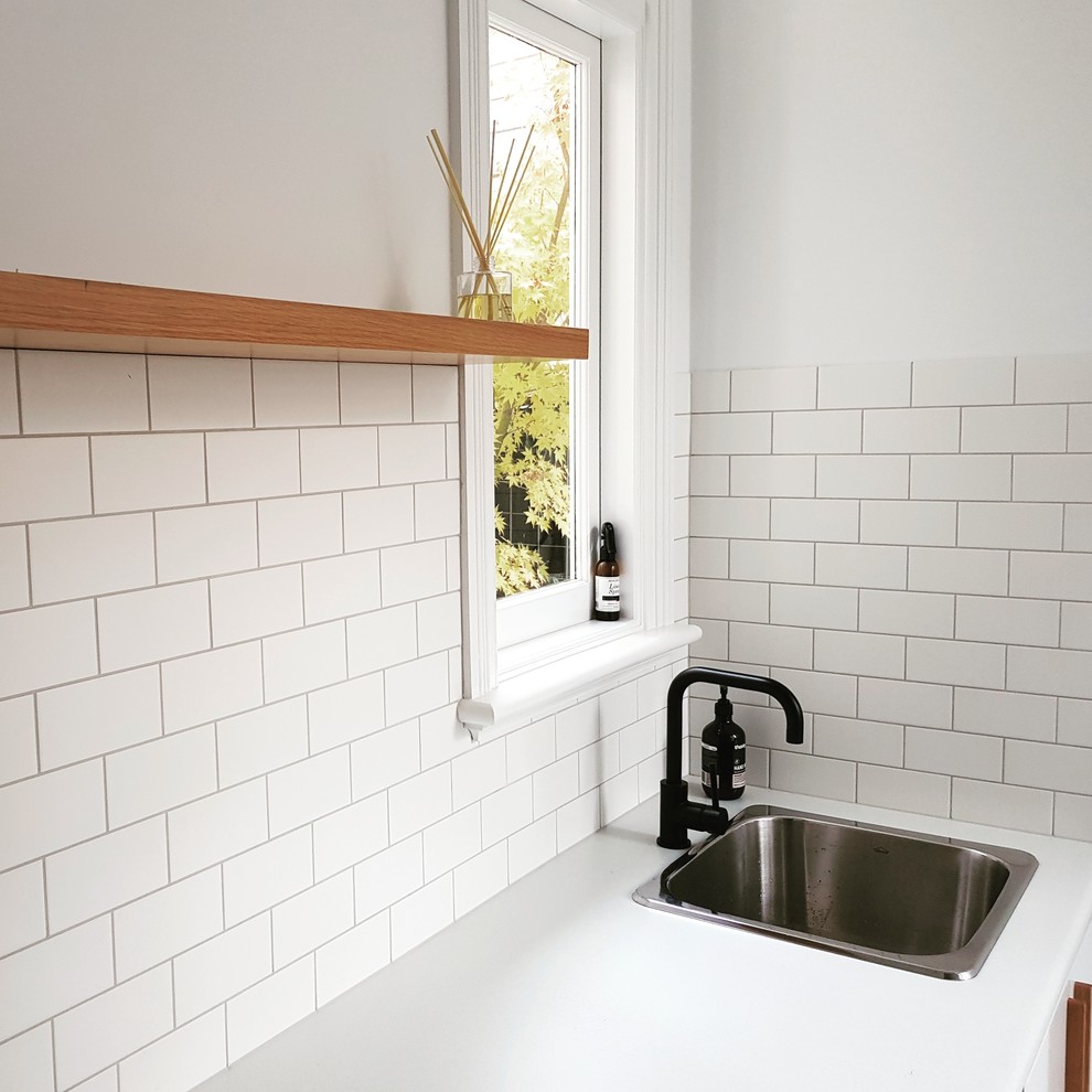 Inspiration for a large contemporary galley dedicated laundry room in Melbourne with a drop-in sink, flat-panel cabinets, white cabinets, quartz benchtops, white walls, a side-by-side washer and dryer and white benchtop.