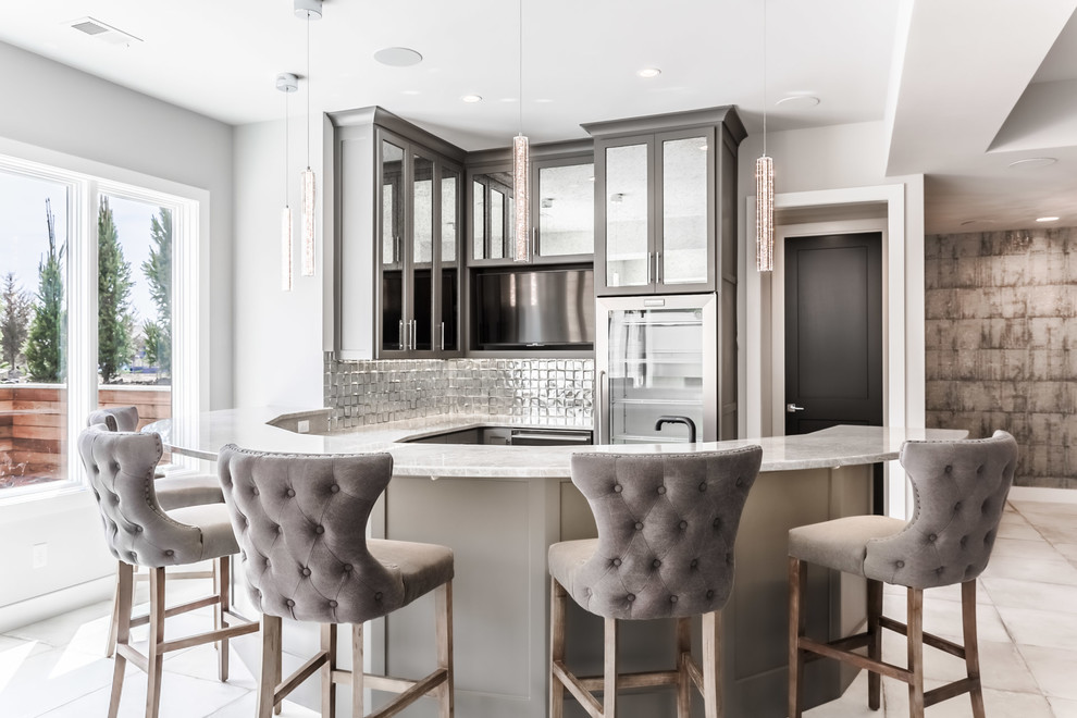 Photo of a transitional u-shaped wet bar in Kansas City with shaker cabinets, grey cabinets, grey splashback, beige floor and beige benchtop.