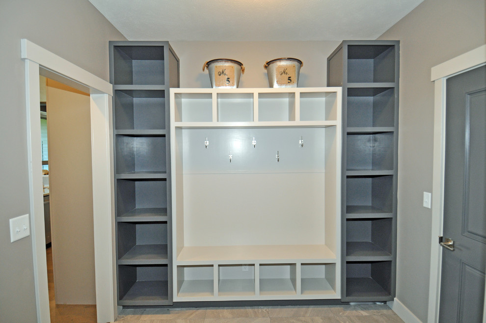 This is an example of a mid-sized transitional mudroom in Other with grey walls, porcelain floors, a single front door and a gray front door.