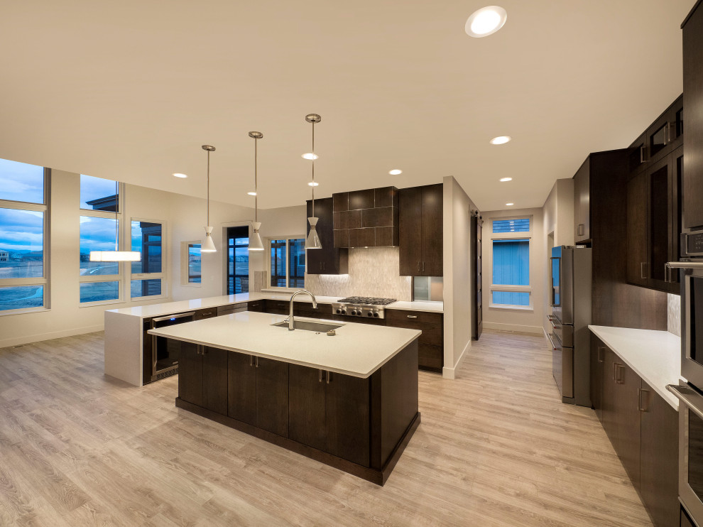 Photo of a mid-sized contemporary l-shaped open plan kitchen in Denver with an undermount sink, flat-panel cabinets, dark wood cabinets, quartz benchtops, beige splashback, porcelain splashback, stainless steel appliances, light hardwood floors, with island, beige floor and white benchtop.