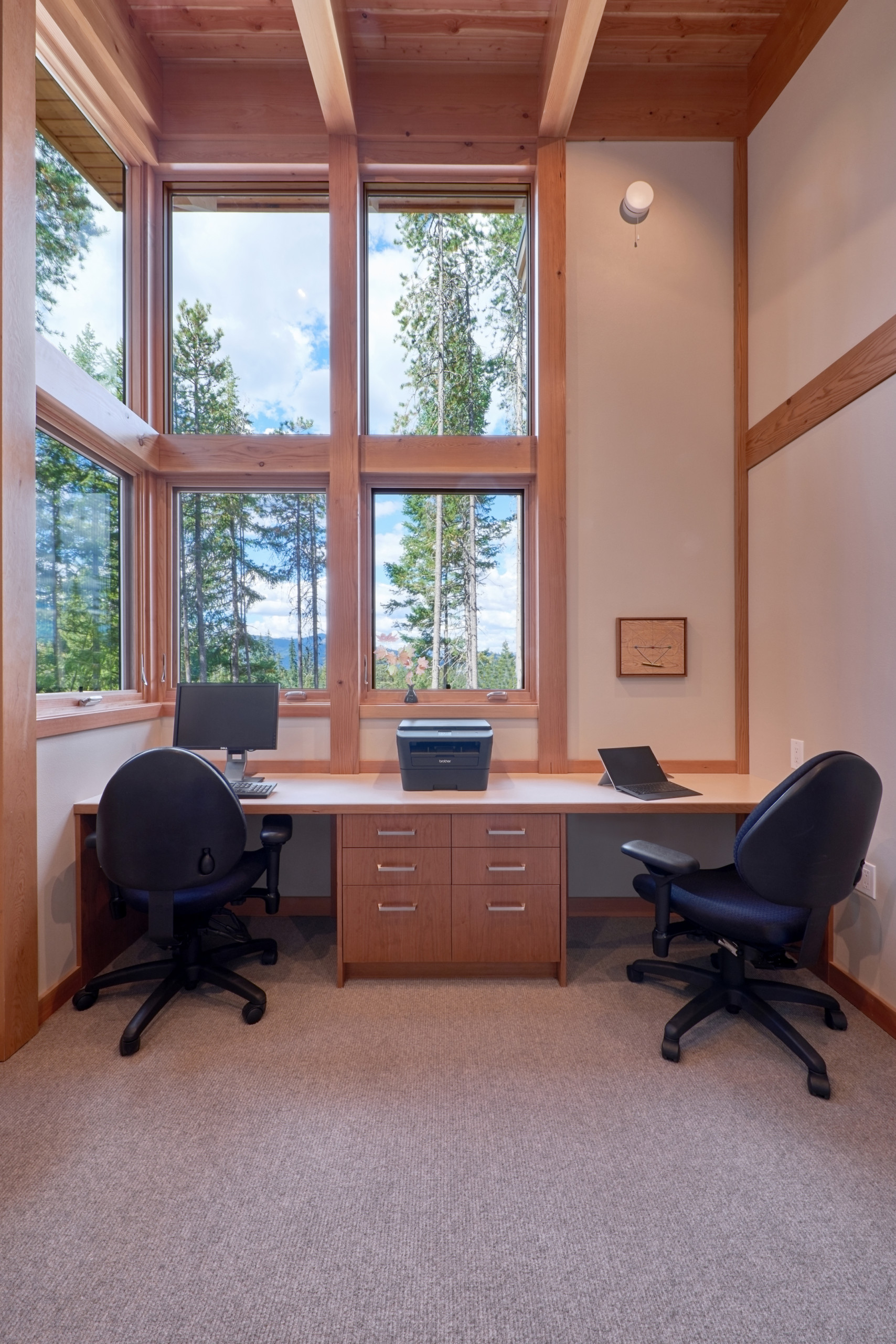 View of the office with built-in desk and vertical grain cherry drawers; window