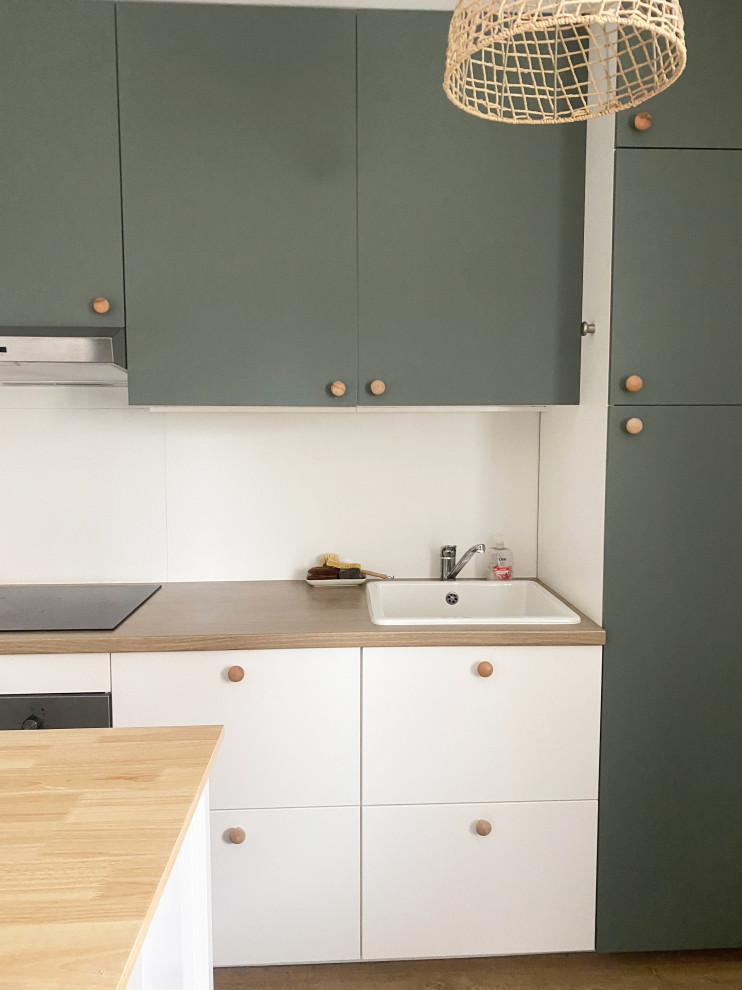 Foto på ett litet nordiskt linjärt kök med öppen planlösning, med en enkel diskho, luckor med profilerade fronter, laminatbänkskiva, integrerade vitvaror, laminatgolv och en köksö
