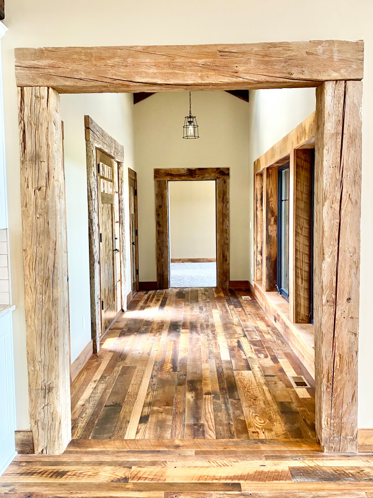 Immagine di una piccola porta d'ingresso rustica con pavimento in legno massello medio, una porta singola e una porta in legno bruno