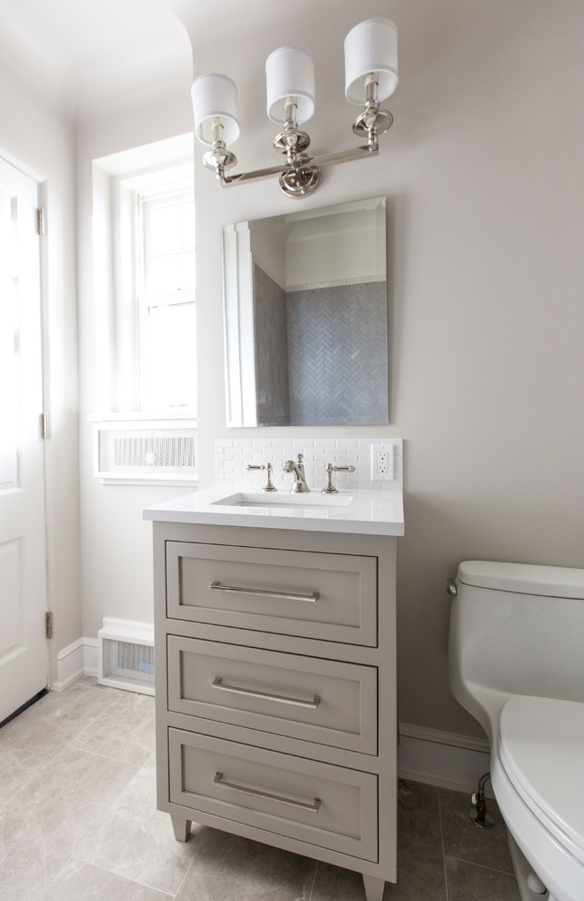 Design ideas for a mid-sized transitional master bathroom in Kansas City with shaker cabinets, grey cabinets, a drop-in tub, a shower/bathtub combo, a one-piece toilet, white tile, grey walls, ceramic floors, a console sink, engineered quartz benchtops, grey floor, an open shower and white benchtops.
