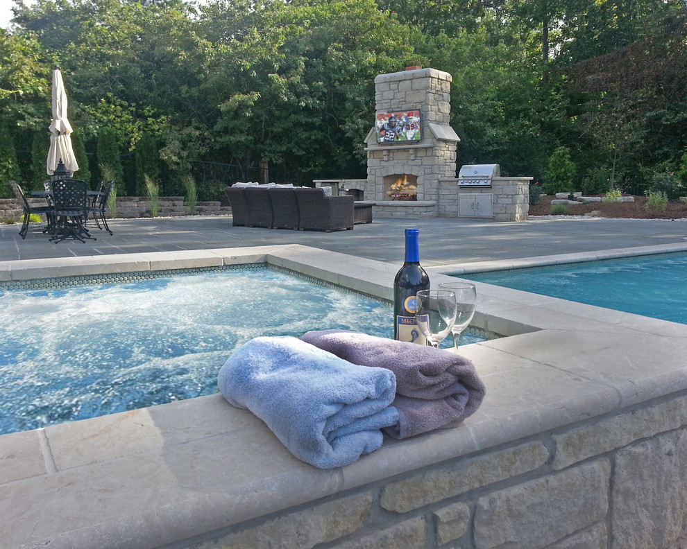 Photo of a mid-sized traditional backyard rectangular lap pool in St Louis with a hot tub and concrete pavers.