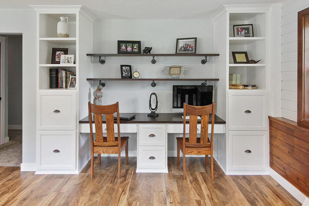 This is an example of a small country home office in Other with grey walls, vinyl floors, a built-in desk and brown floor.