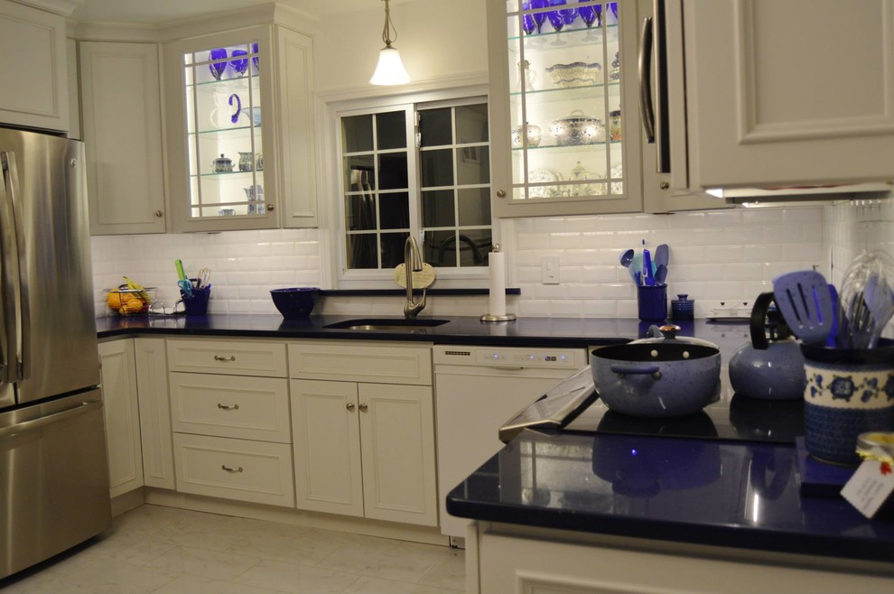Eat-in kitchen - large u-shaped porcelain tile eat-in kitchen idea in Boston with white cabinets, white backsplash, stainless steel appliances, an island, a single-bowl sink, recessed-panel cabinets, quartz countertops and cement tile backsplash