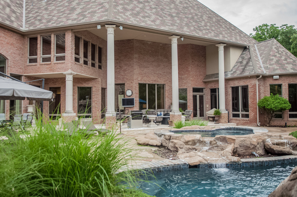 Expansive traditional backyard custom-shaped natural pool in Other with a hot tub and stamped concrete.