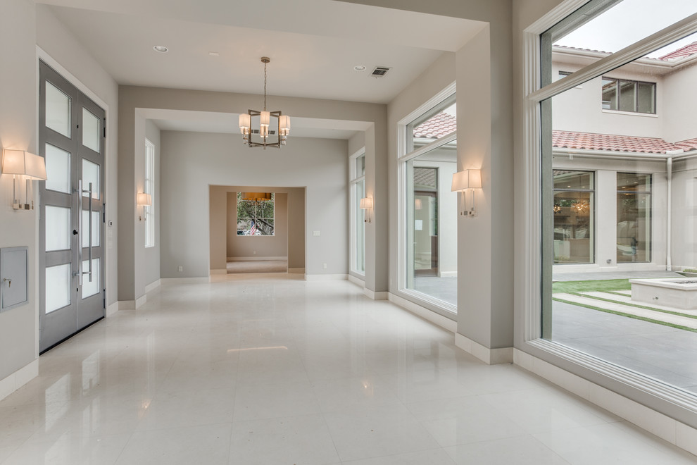 Large transitional foyer in Dallas with grey walls, limestone floors, a double front door, a metal front door and white floor.