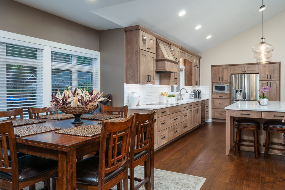 Inspiration for a large transitional l-shaped medium tone wood floor and brown floor open concept kitchen remodel in Seattle with an undermount sink, shaker cabinets, light wood cabinets, quartz countertops, white backsplash, porcelain backsplash, stainless steel appliances, an island and white countertops