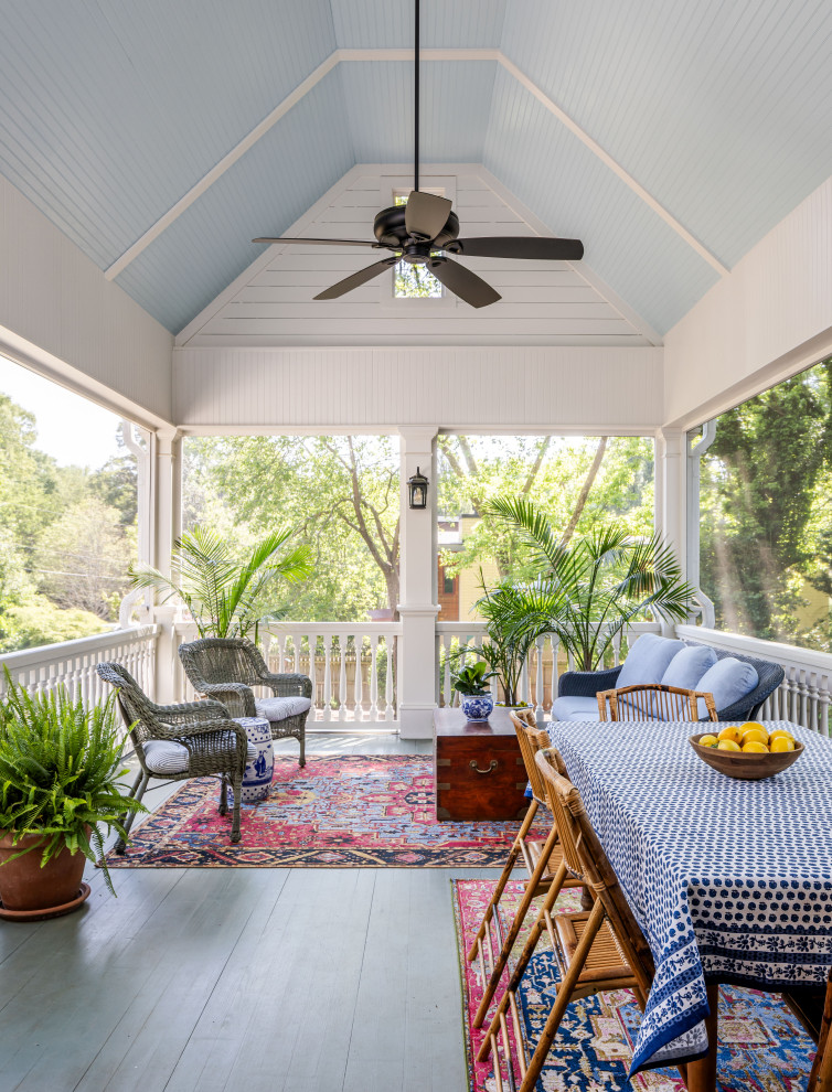 This is an example of a traditional screened-in and wood railing porch column design in Atlanta with a roof extension.