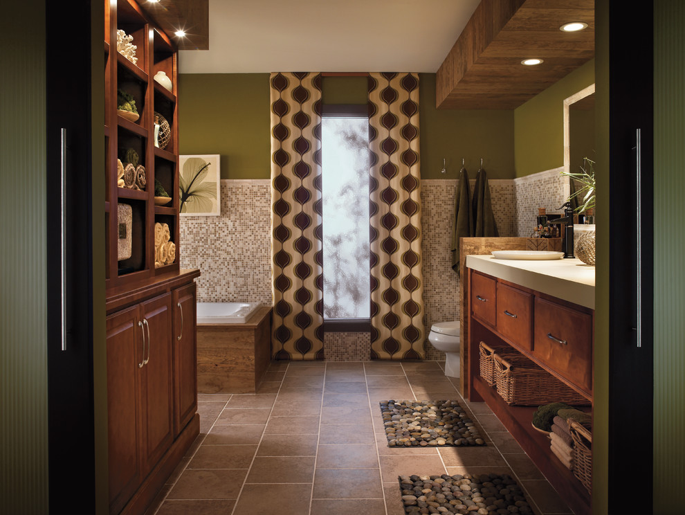 This is an example of a traditional bathroom in San Francisco with medium wood cabinets, a drop-in tub, beige tile, mosaic tile, green walls, raised-panel cabinets and brown floor.