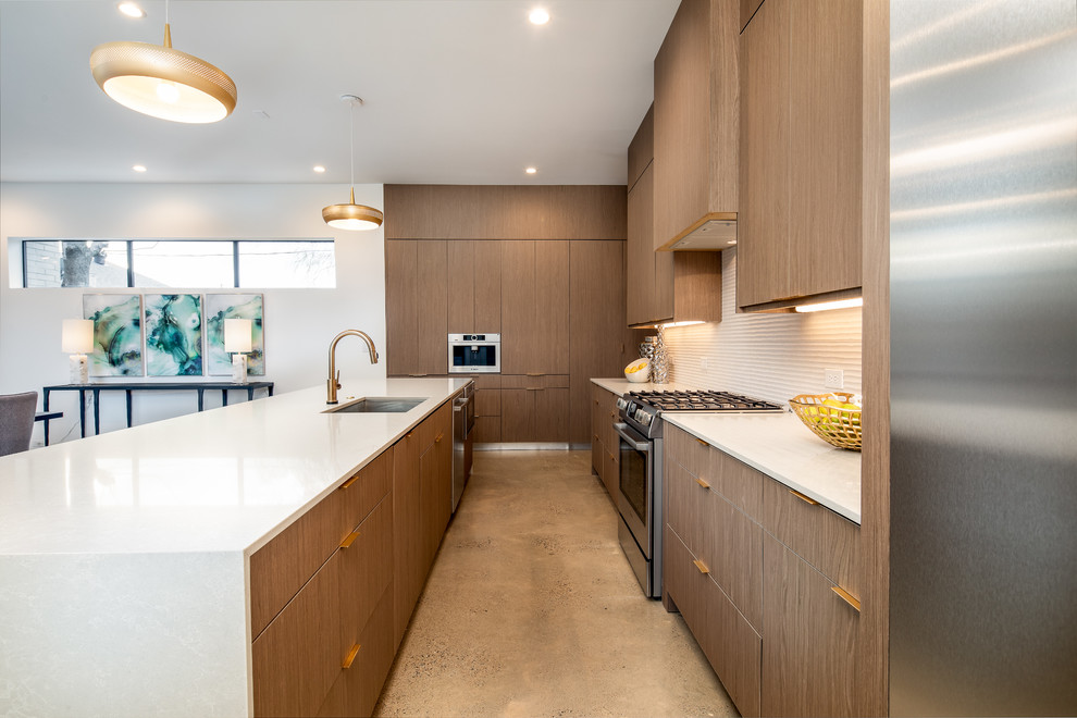 Large modern l-shaped open plan kitchen in Dallas with an undermount sink, flat-panel cabinets, dark wood cabinets, white splashback, stainless steel appliances, with island, white benchtop, quartz benchtops, concrete floors and grey floor.