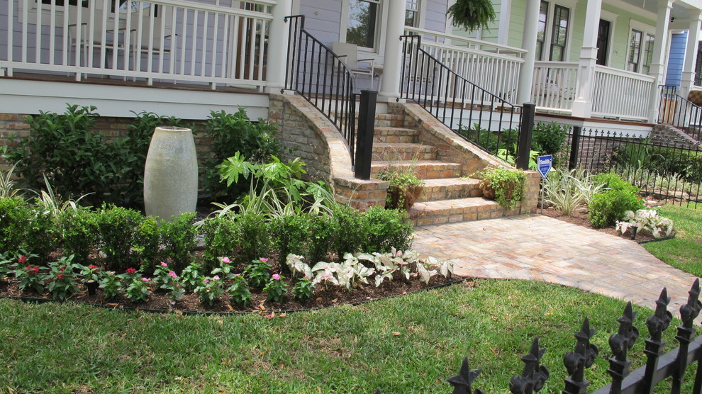 Design ideas for a small traditional front yard verandah in Houston with a water feature and brick pavers.