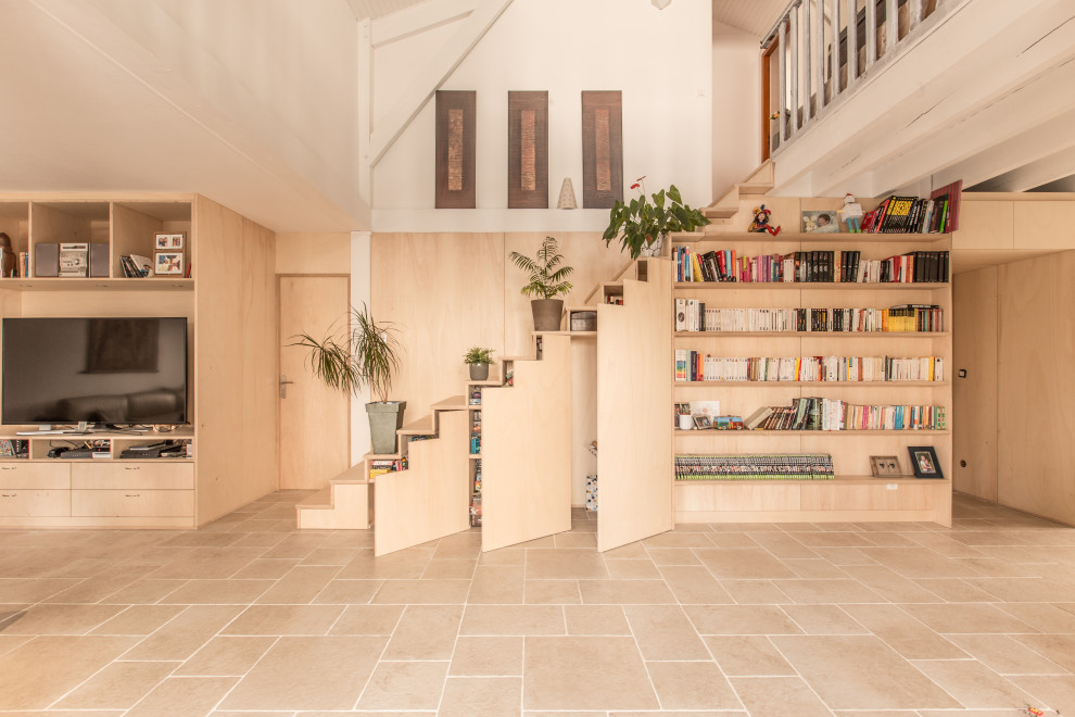 Réalisation d'une grande salle de séjour design en bois ouverte avec une bibliothèque ou un coin lecture, un mur multicolore, un sol en travertin, un poêle à bois, un téléviseur encastré, un sol beige et poutres apparentes.