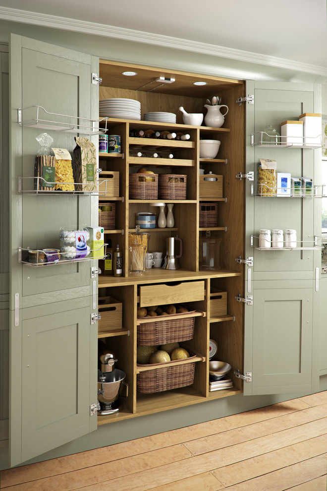 Design ideas for a traditional kitchen pantry in Other with green cabinets and light hardwood floors.