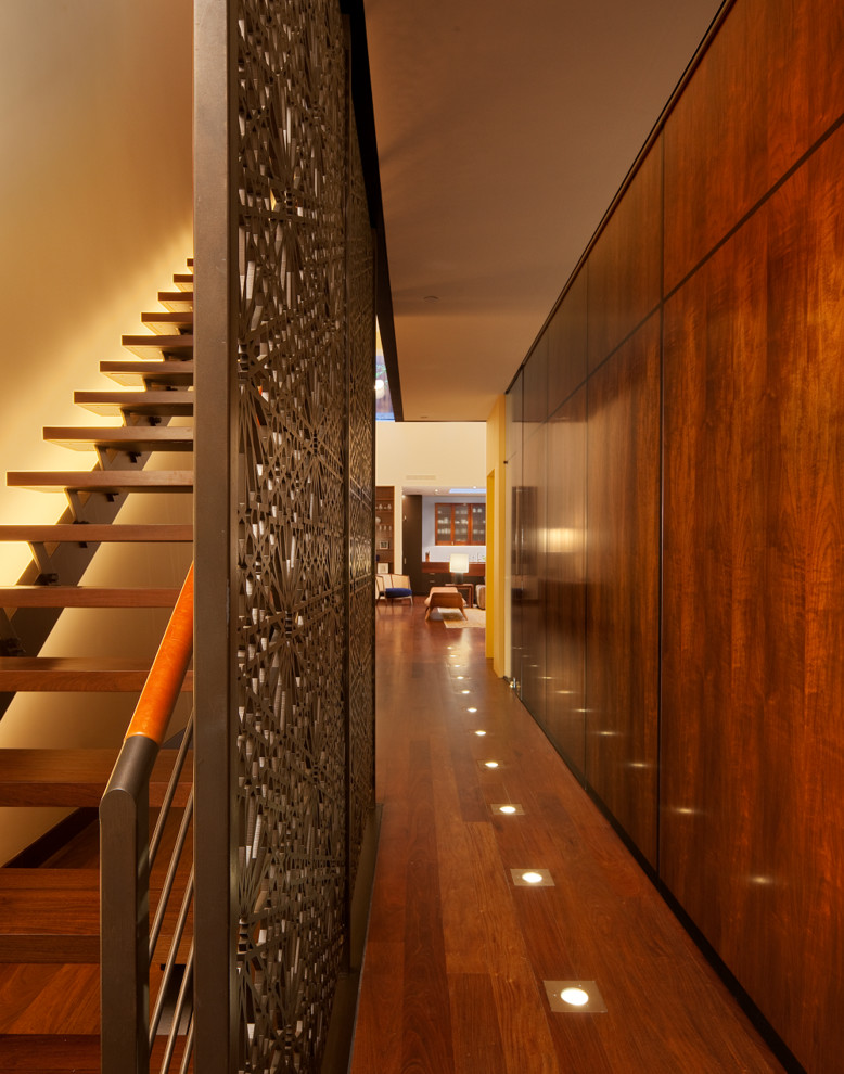 Contemporary hallway in New York with dark hardwood floors.
